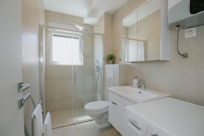 Ein modernes Badezimmer mit Duschkabine, Toilette, Waschbecken und Badewanne.