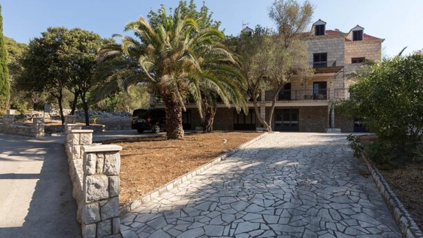 A stone-paved pathway leading to a building with a stone facade, surrounded by trees and a clear sky. - Rooms Villa Basica - Basic Double Room With Forest View (Mljet)