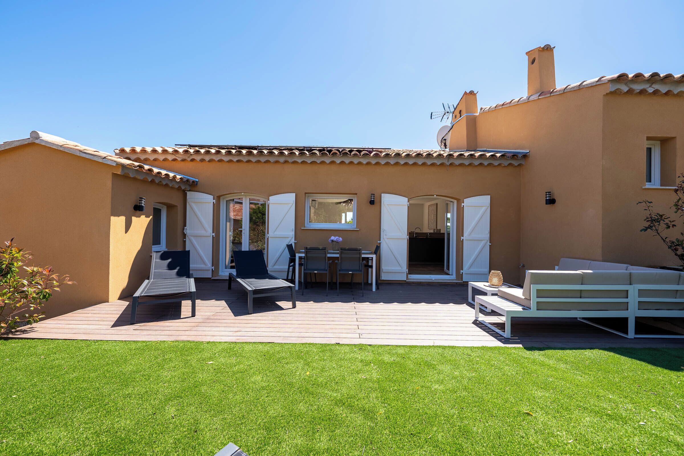 Une maison dotée d’un patio, d’un coin repas et d’un espace salon.