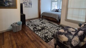 A bedroom with a bed, a ceiling fan, a patterned rug, a pet bed, and a couch. - Wonderful 3-bedroom cottage in charming Diboll (Diboll)