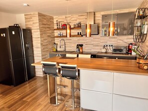 Eine moderne Küche mit einer Holzausziehtheke, Edelstahlgeräten und einem eingebauten Backofen.