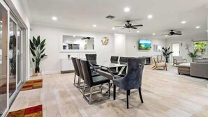 Un salon moderne comprenant un coin repas, un canapé et un téléviseur.