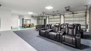 Un vaste espace intérieur comprenant un coin salon avec des canapés en cuir noir et un banc.