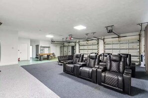 Ein großzügiger Innenbereich mit einer Sitzecke, ausgestattet mit schwarzen Ledersofas und einer Bank.