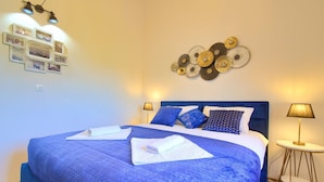 Ein Hotelzimmer mit einem großen Bett, zwei Nachttischlampen, einer Wandleuchte und einem dekorativen Wandbild.