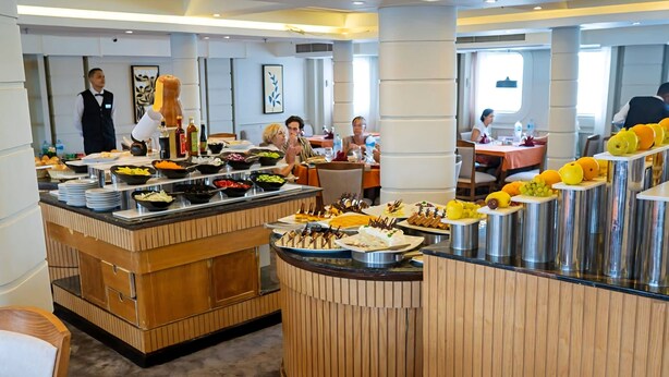 Un'area buffet con diversi cibi e un cameriere in divisa.
