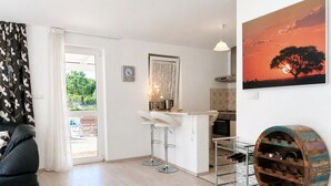 Una cocina moderna con un lavamanos, taburetes de bar y una estantería para vinos.
