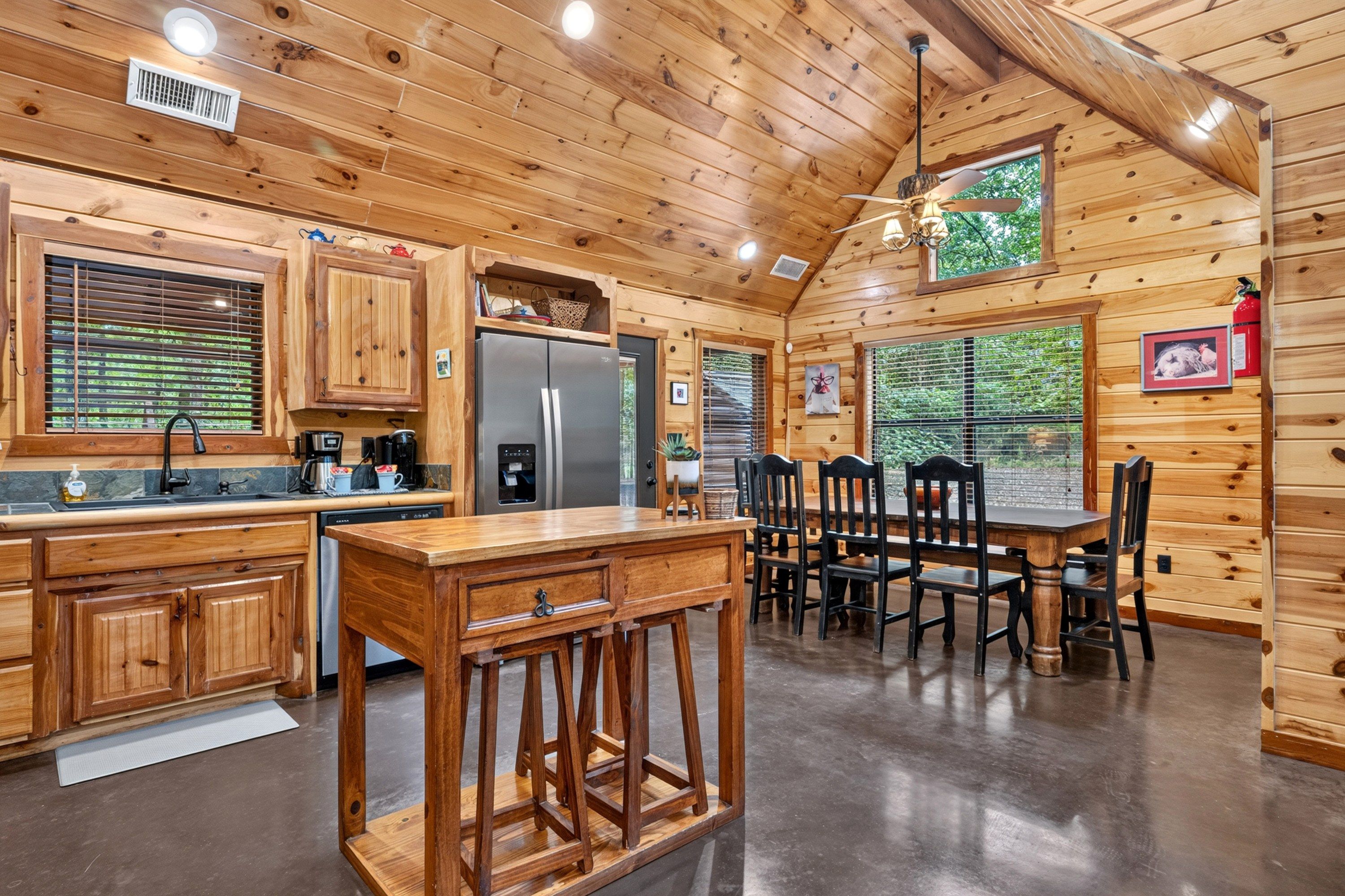 Un intérieur en bois comprenant un coin cuisine équipé d’un réfrigérateur, d’une cuisinière et d’une table à manger avec des chaises.