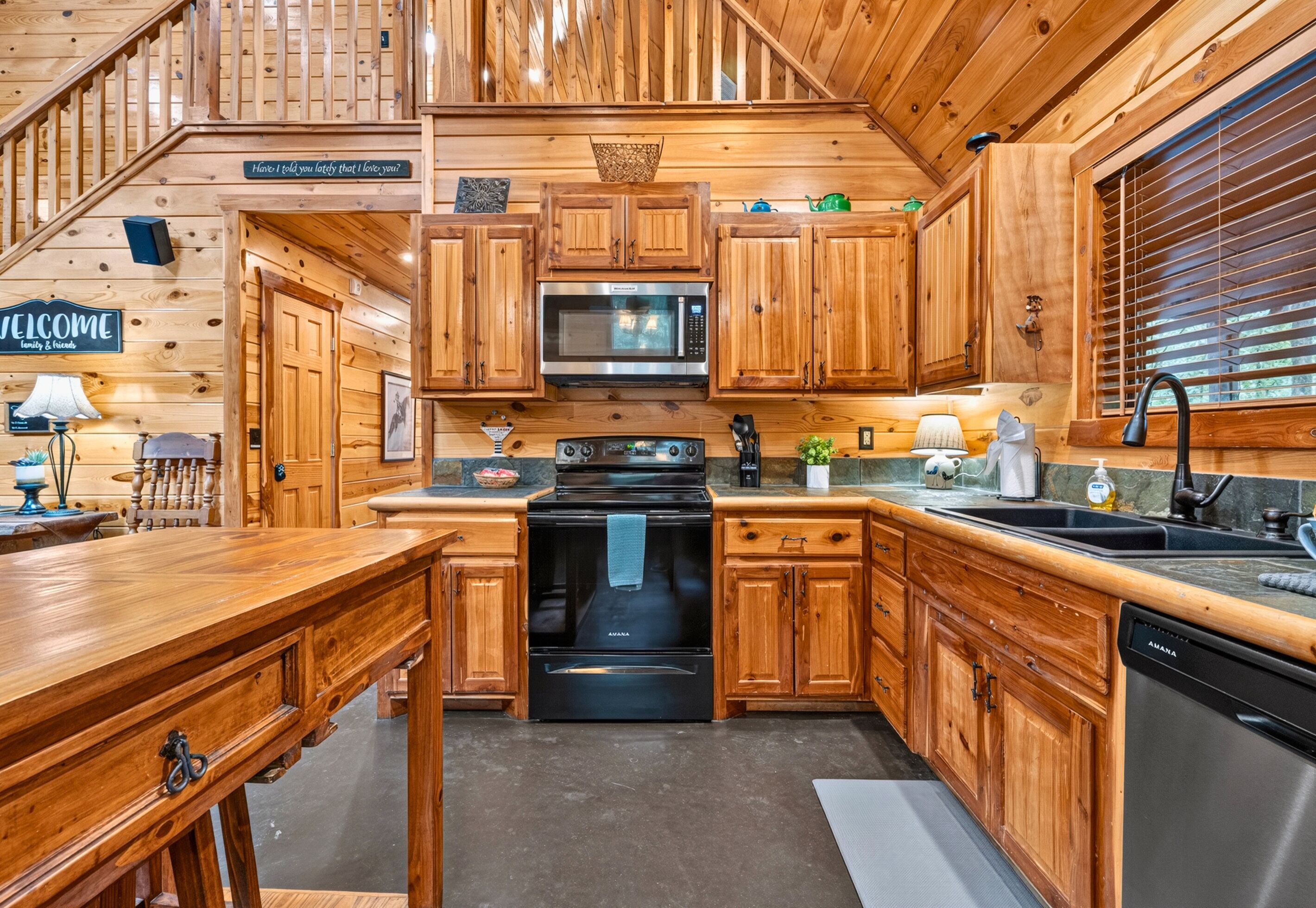 L’intérieur d’un chalet en bois comprend une cuisine équipée d’un four à micro-ondes, d’une cuisinière et d’un évier.