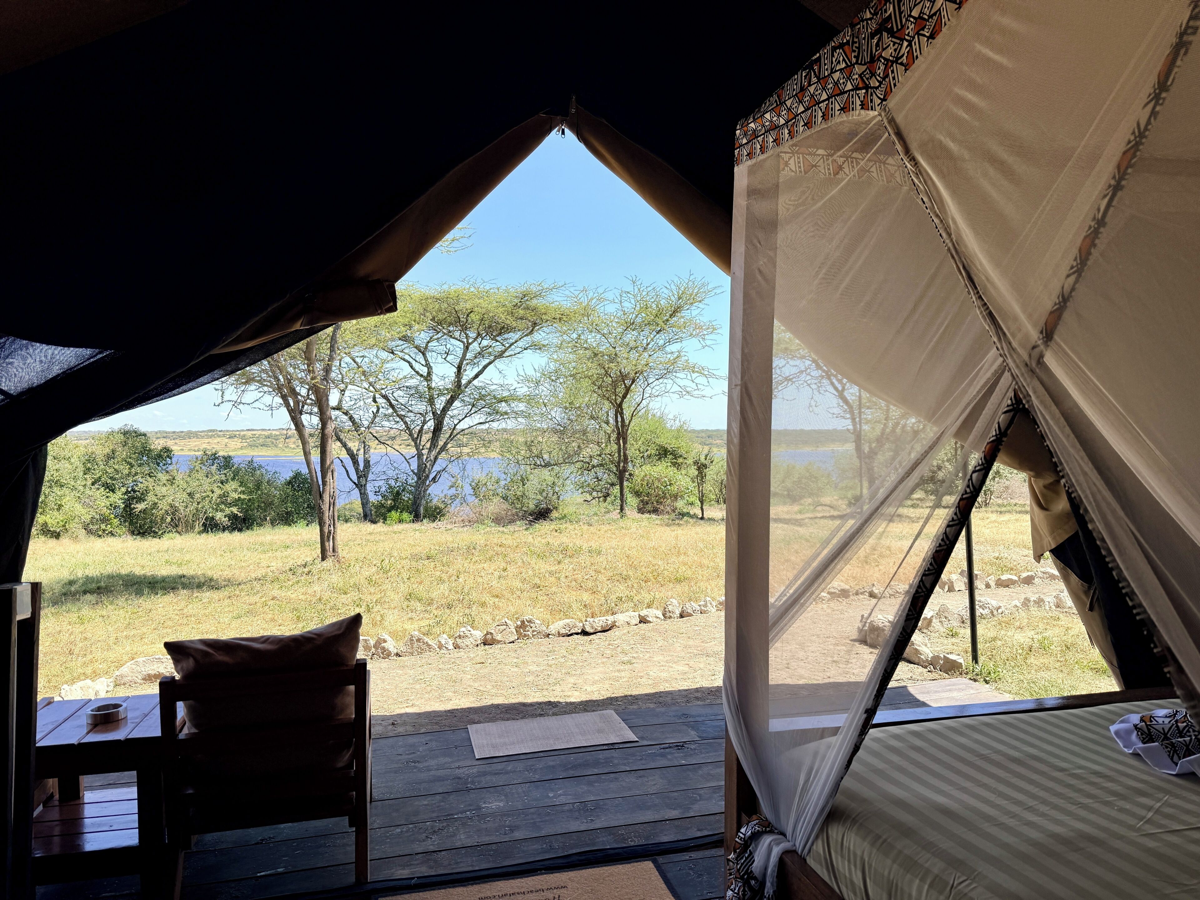 Una carpa con vista a un lago y árboles.
