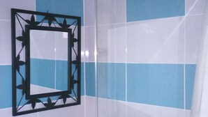 Een badkamer met een wastafel, spiegel en douche.