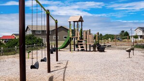 Ein Spielplatz mit Schaukeln, Rutschen und Klettergerüsten.