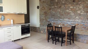 A kitchen with white cabinets, a stove, and a dining table with chairs.