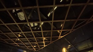 Een bar met een counter, zitplaatsen en hanglampen.