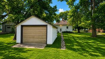 A single-story house with a garage, surrounded by a well-maintained lawn and trees.