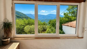 Ein Zimmer mit großem Fenster und Blick auf eine Berglandschaft.