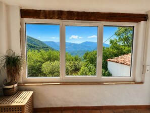 A room with a large window overlooking a mountainous landscape. - A Provençal house between the sea and the mountains (Saint-Blaise)