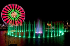 A large Ferris wheel and a fountain display at night. - *Spacious 3BD w/ Hot Tub + POOL Access + Jacuzzis* (Sevierville)