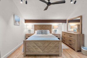 A bedroom with a bed, bedside tables, a dresser, a ceiling fan, and a wall-mounted mirror. - New Rental-3 beds, 2.5 baths, New Seabury (Mashpee)