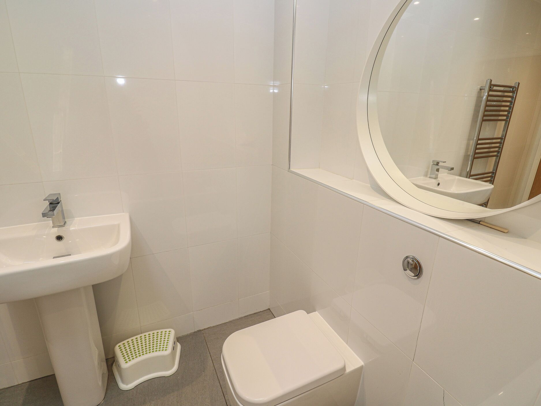 A bathroom with a sink, toilet, and a mirror.