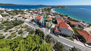 Vista aerea di una cittadina costiera con edifici, una strada e una spiaggia.