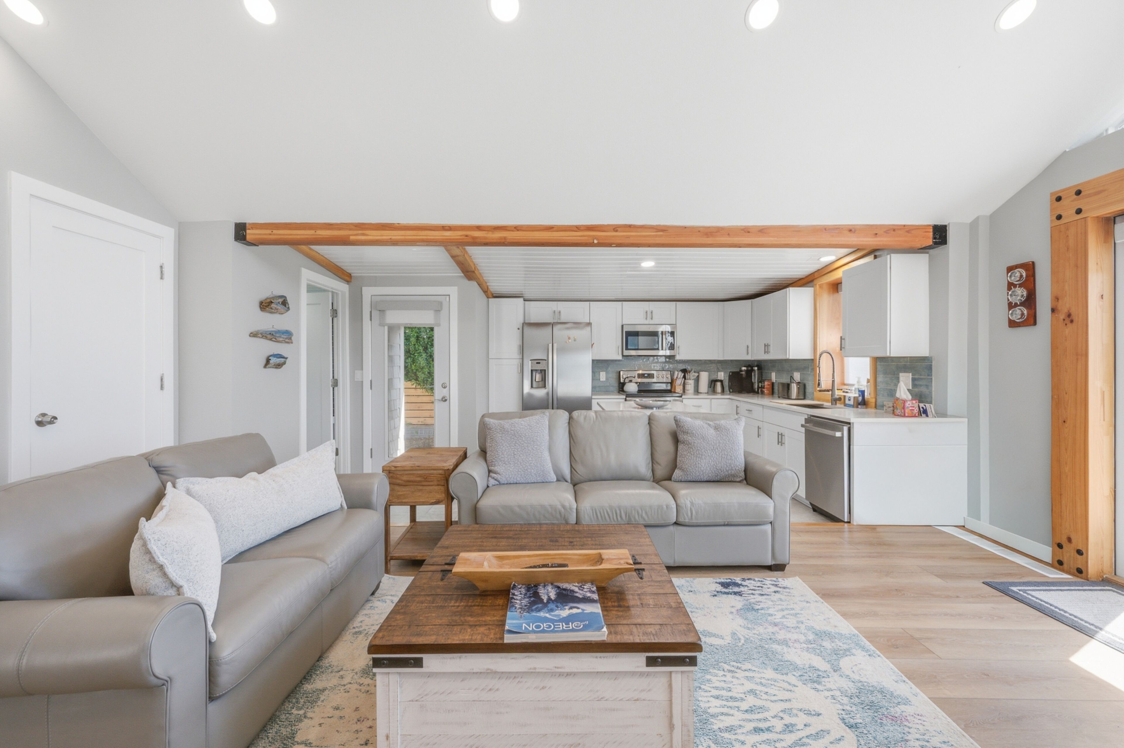 A modern living room with a sofa, coffee table, and kitchen in the background.