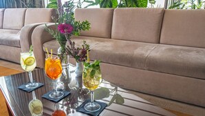 A glass-top coffee table with drinks and a vase of flowers in a living room. - Hotel Issa - Triple Room Sea View (Vis)