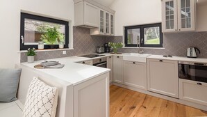 Uma cozinha moderna com ilha central, eletrodomésticos embutidos e amplas janelas.