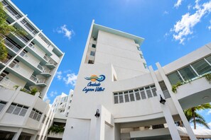 A modern hotel building with a prominent logo, multiple balconies, and a clear sky. - Oceanfront * Patio * Full Generator * Pool * OSJ (San Juan)
