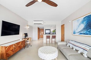 A modern living room with a flat-screen TV, a dining area, and a kitchen. - Waterfront serenity in the heart of the city… (San Juan)