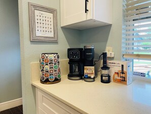 Eine Küchenarbeitsplatte mit Kaffeemaschine, einer Keurig-Maschine, einem Kaffee-Pod-Halter und einer Keurig Café-Box.
