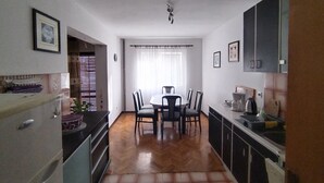 Eine kleine Küche mit Essbereich, Holzboden und Deckenventilator.