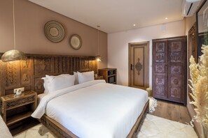 A bedroom with a large bed, wooden headboard, bedside tables, and a wardrobe. - La kasbah d'ourika (Sti Fadma)