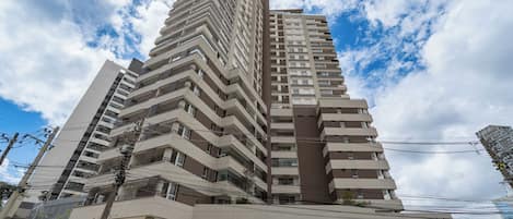 A multi-story building with balconies, a flat roof, and a clear sky.