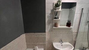 A bathroom with a toilet, sink, and shower. - Apartment Sleeps 6 With Air Conditioning (Manchester)