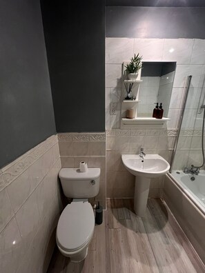 Ein Badezimmer mit Toilette, Waschbecken und Dusche.