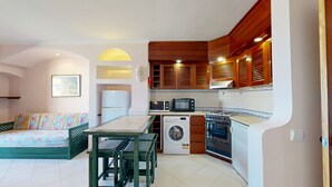 Una cocina compacta equipada con lavadora, microondas y estufa.