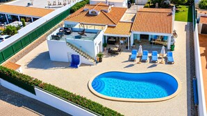 Ein Poolbereich auf dem Dach mit Liegestühlen, einem kleinen Pool und einer Treppe, die zu einer oberen Ebene führt.