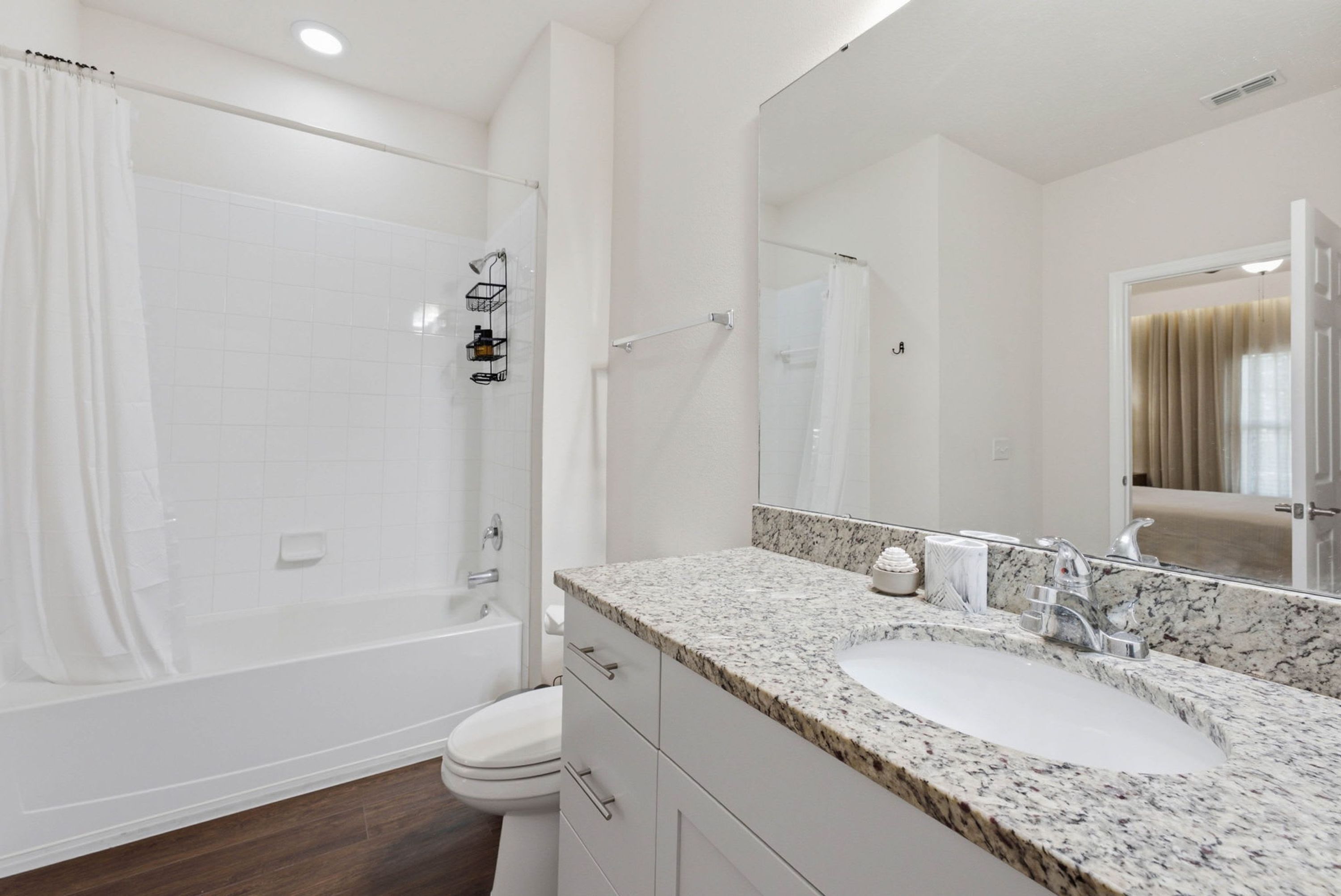 A modern bathroom with a shower, toilet, and sink.