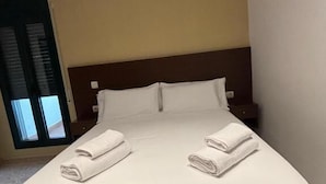 Ein Hotelzimmer mit Bett, Kissen und Nachttisch.