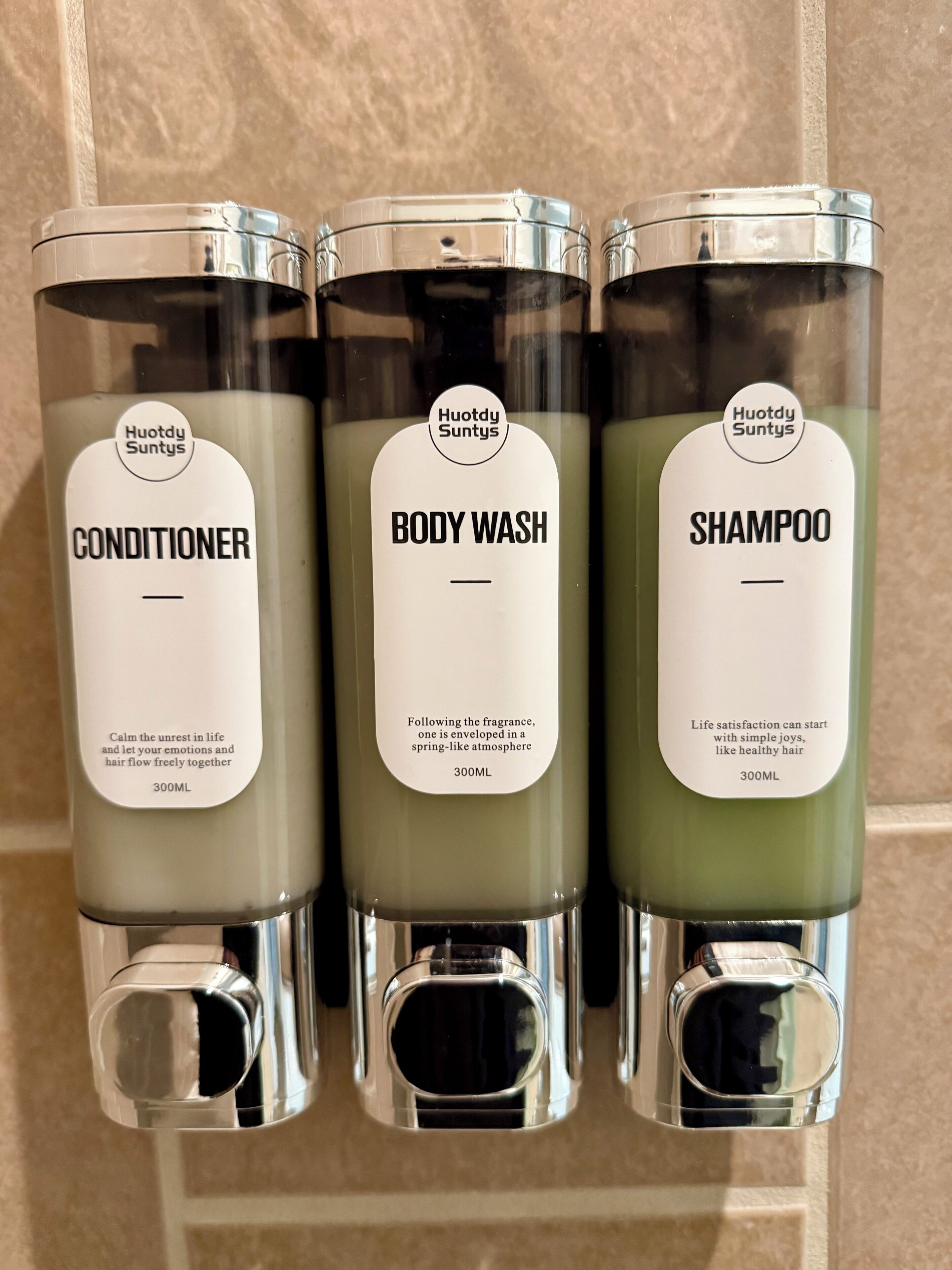 Tres productos Huotdy Suntys: acondicionador, gel de baño y champú, cada uno en una botella de 300 ml.