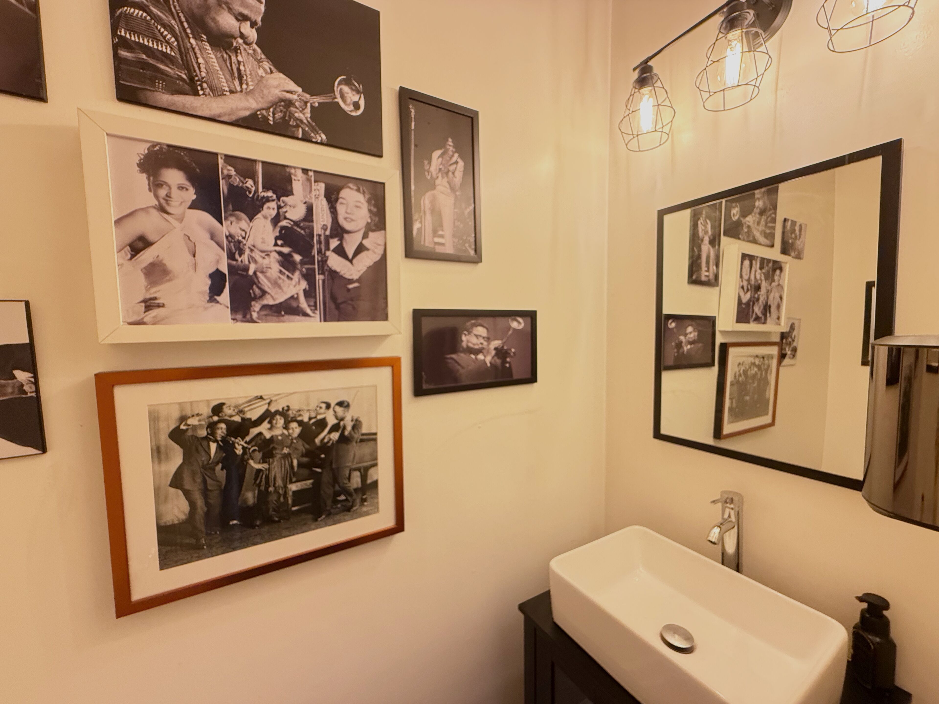 Un baño con lavabo, espejo e iluminación en la pared.