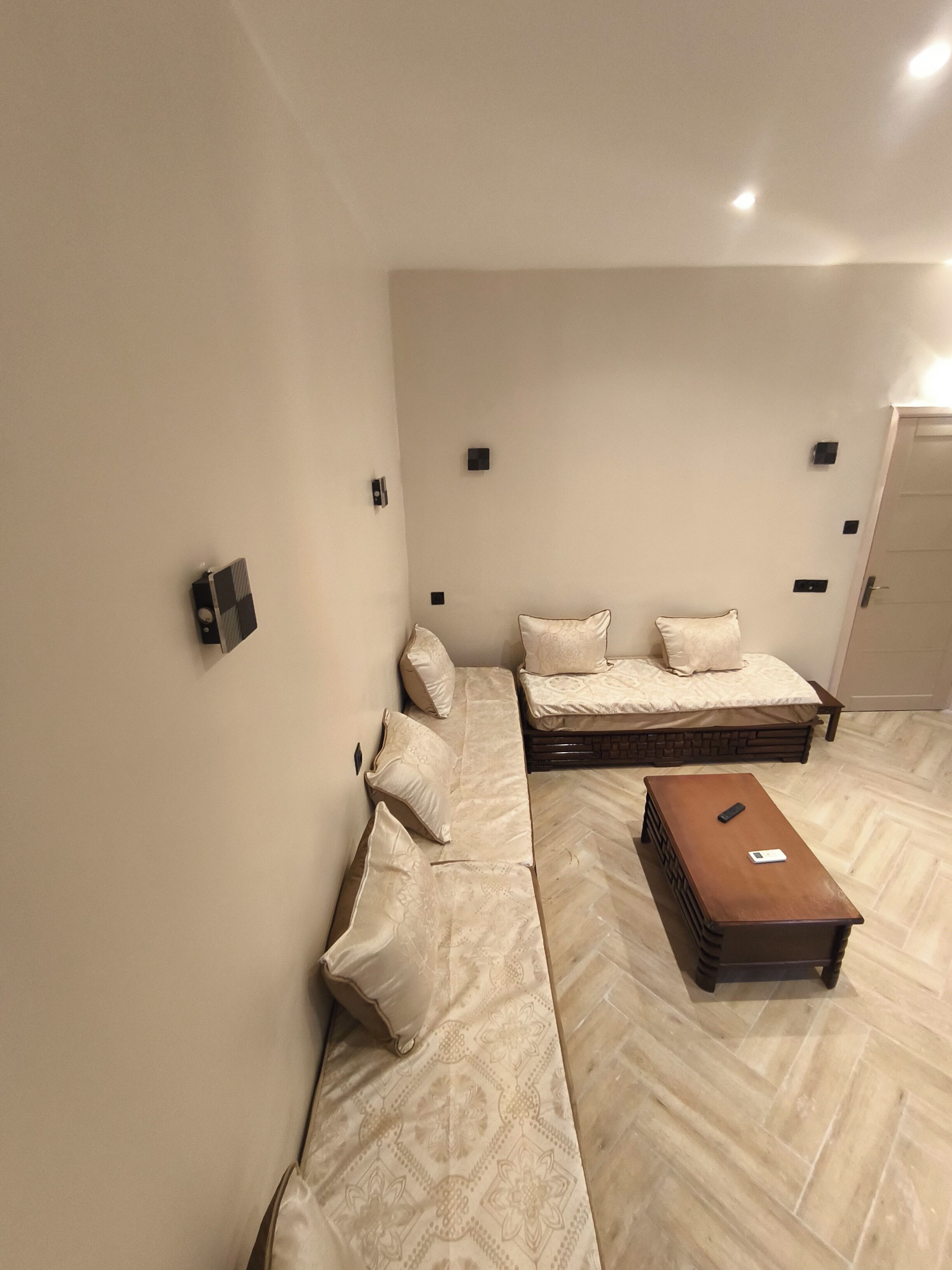 Une chambre à coucher avec un lit, un canapé, une petite table et une porte.