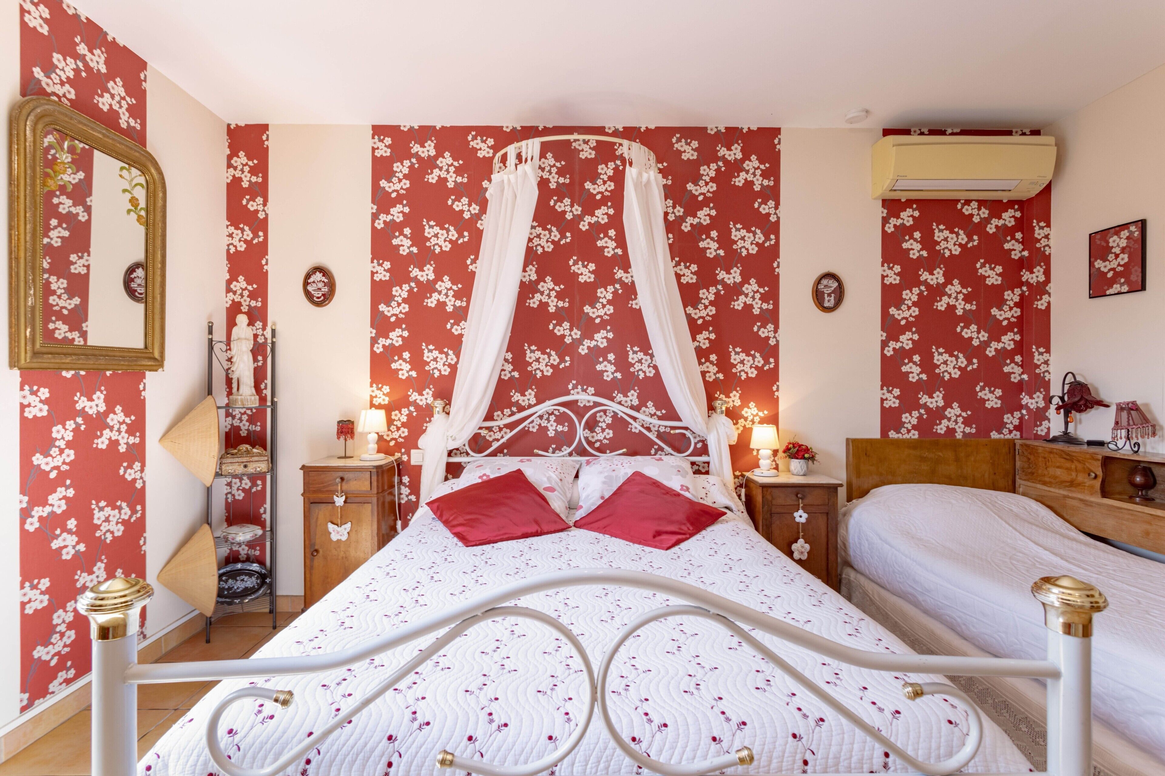 Une chambre à coucher avec un lit à baldaquin, une table de chevet avec une lampe, une commode avec une lampe et une armoire.