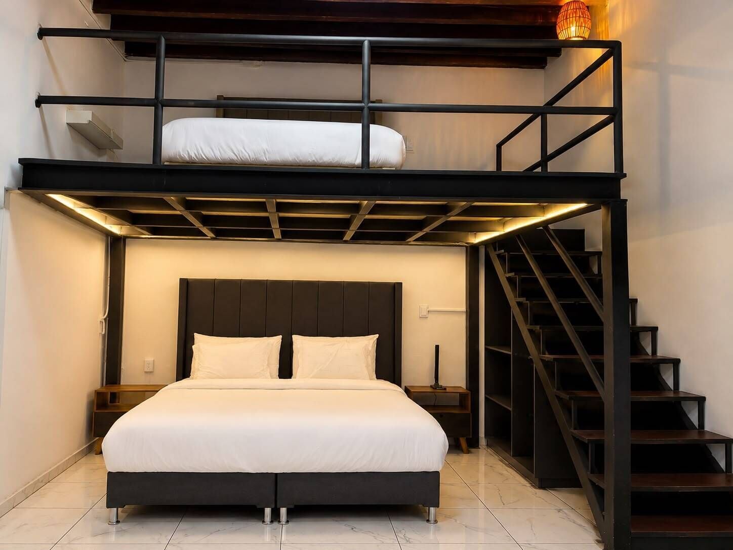 A bunk bed with a lower level bed and a staircase to the upper bunk.