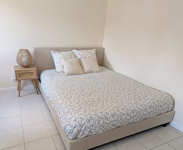 A bedroom with a bed, a nightstand, and a decorative lamp.