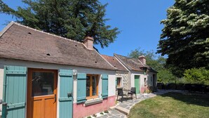 A traditional house with a stone facade, wooden shutters, and a stone pathway leading to the entrance.
