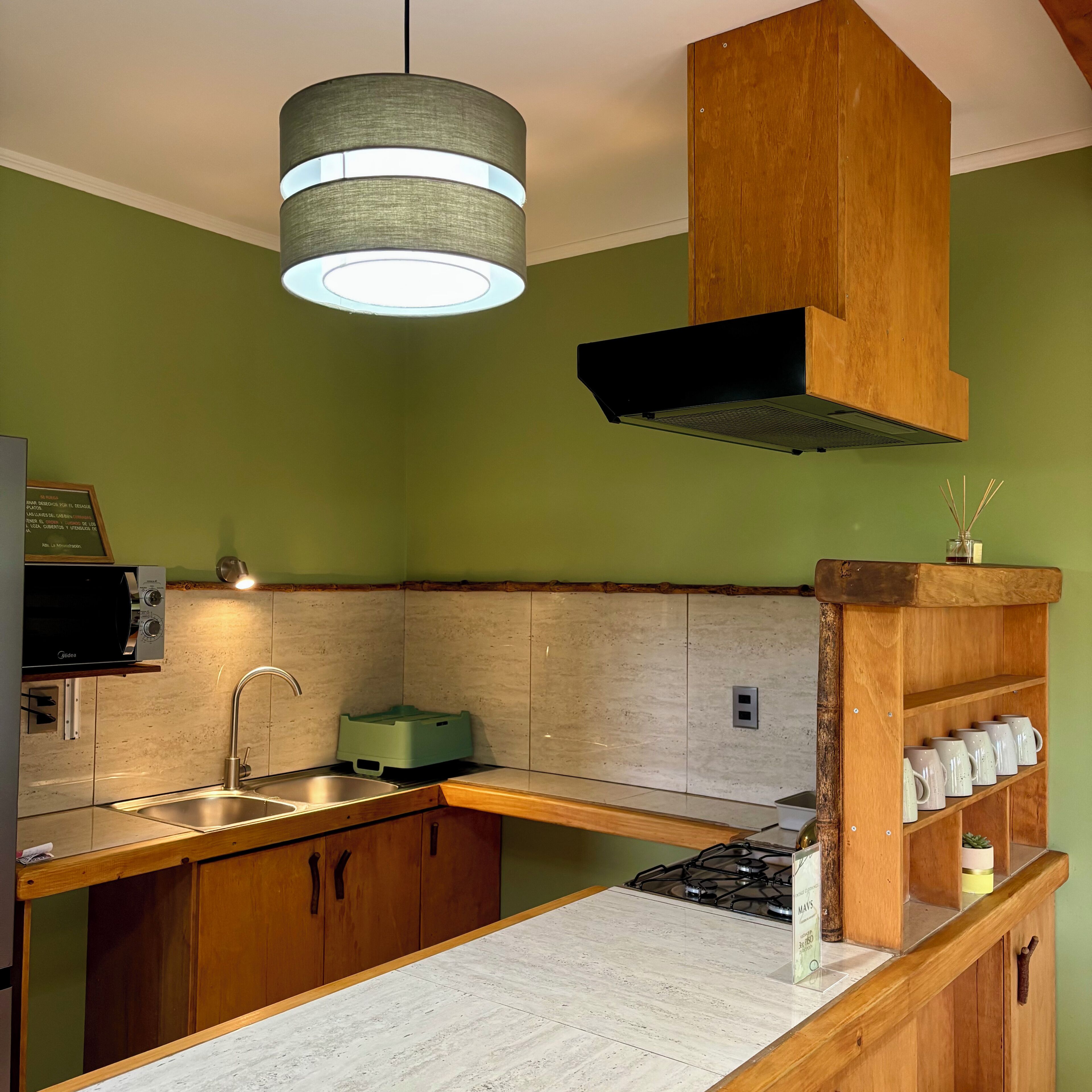 A kitchen with wooden cabinets, a built-in microwave, a gas stove, and a hanging light fixture.