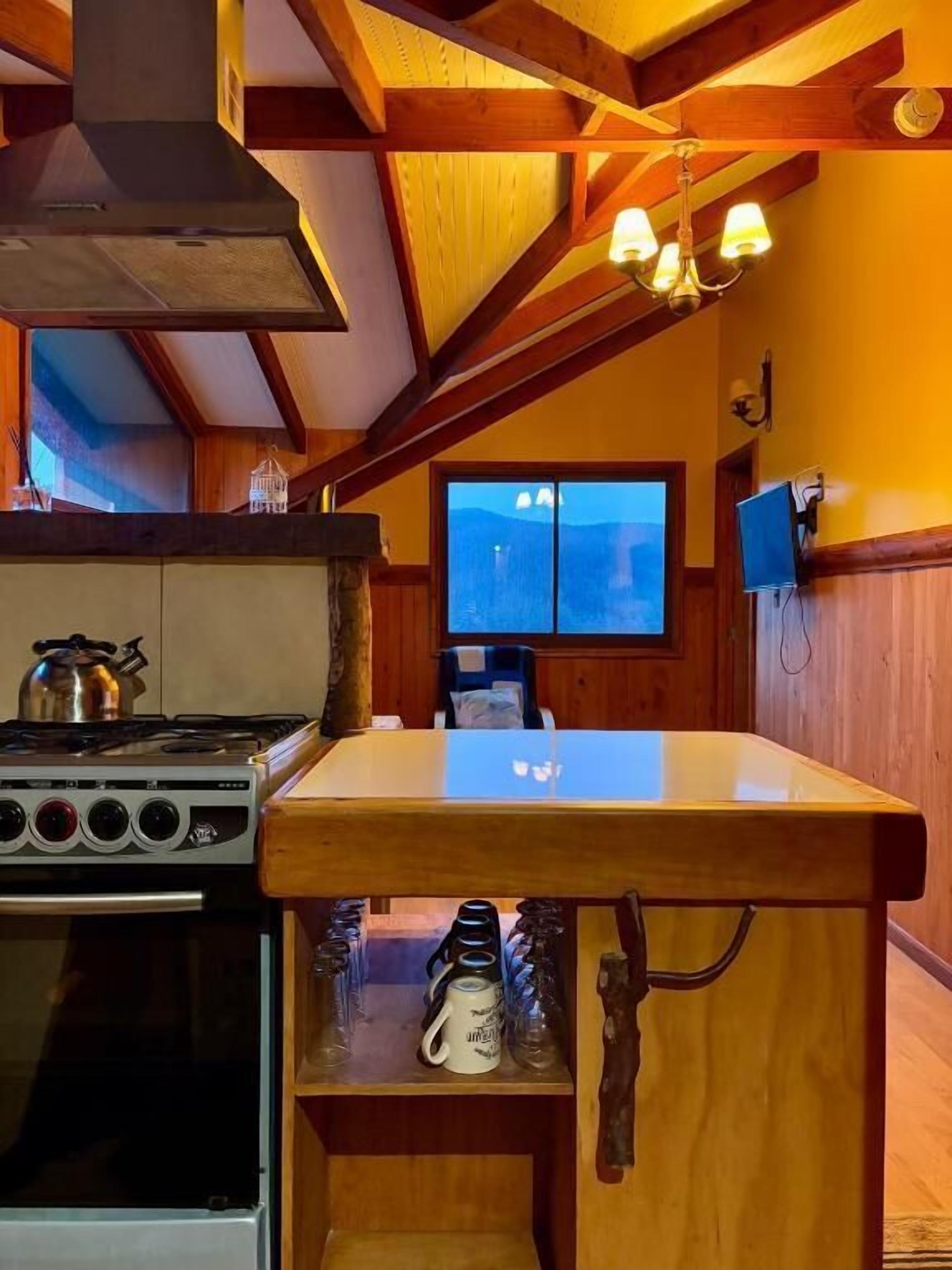 A kitchen with a stove, oven, and wooden counter.