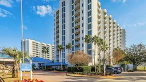 A high-rise hotel with multiple balconies, a registration sign, and a self-parking area. - 🌊The Palms 2411 | Resort Pool Views & Beach Vibes🌊 (Destin)